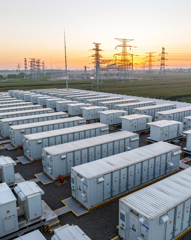 storage units during sunset by transmission lines