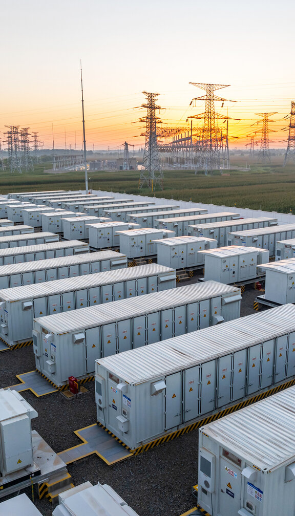 storage units during sunset by transmission lines