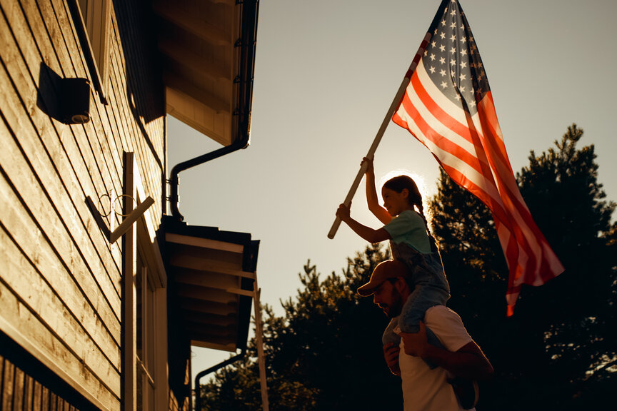 girl putting up american flag 
